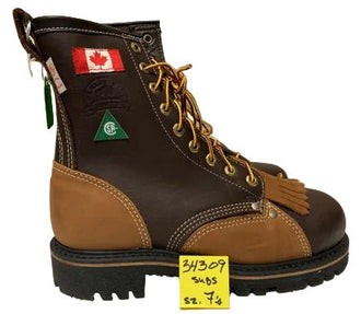 A single brown leather lace-up work boot with tan overlays, a black sole, and a small green Canadian flag patch on the side, photographed on a white surface against a light gray wall.